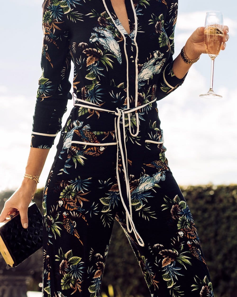tummy tuck patient model in a floral dress holding a glass of wine and a book