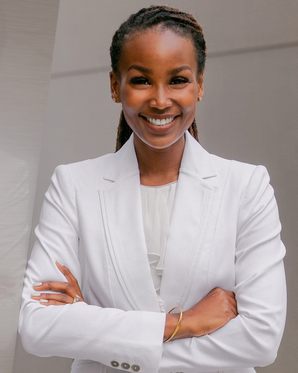 rhinoplasty patient model standing with her arms crossed and smiling