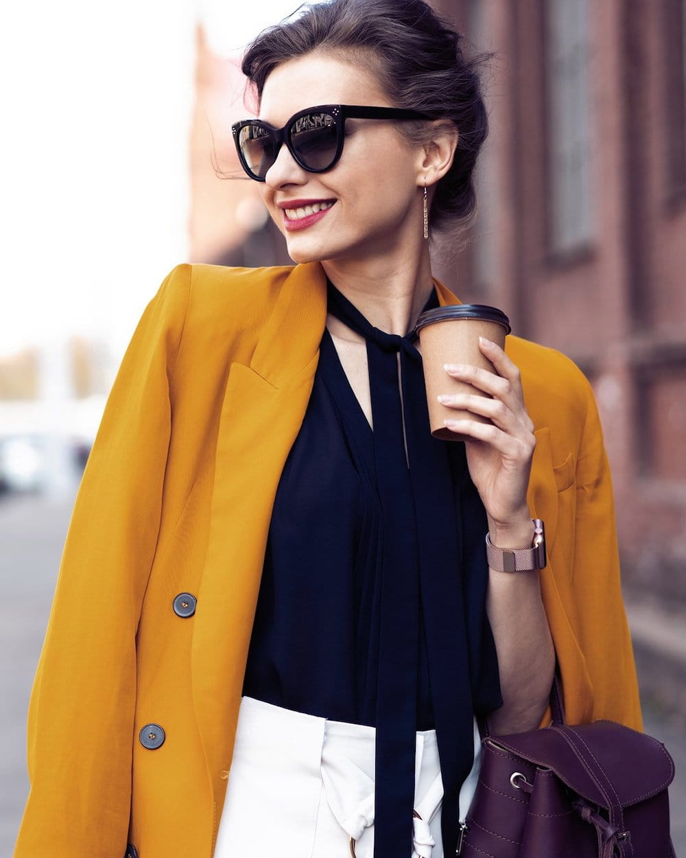 rhinoplasty patient model walking down the street wearing sunglasses and holding a coffee cup
