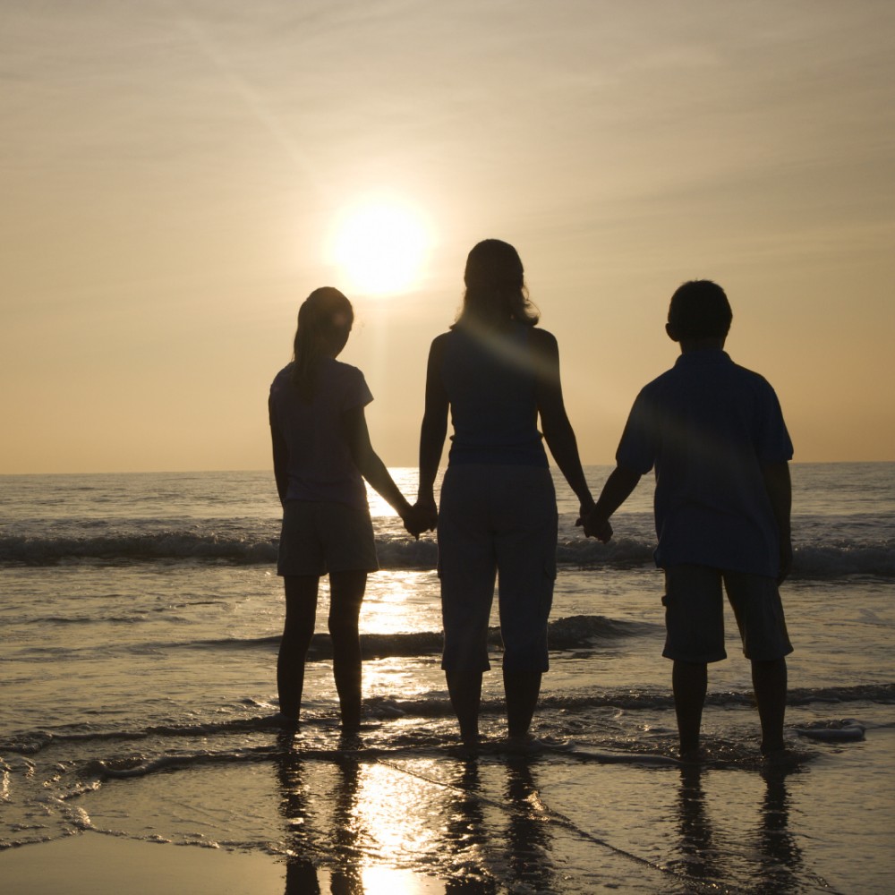 non-surgical mommy makeover patient model holding hands with her children at a beach