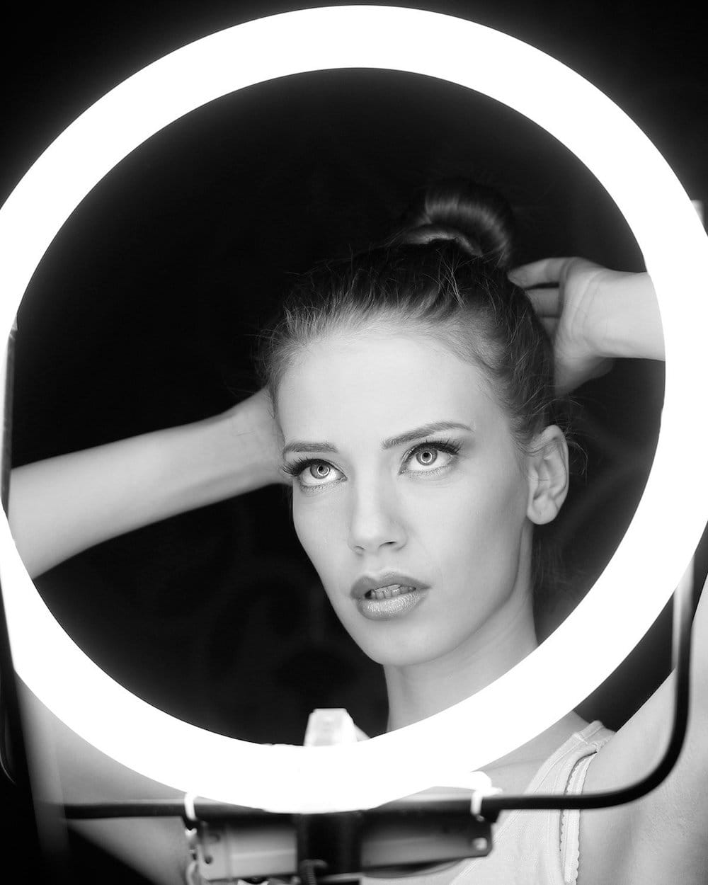 vi peel patient model fixing her hair in front of a ring light