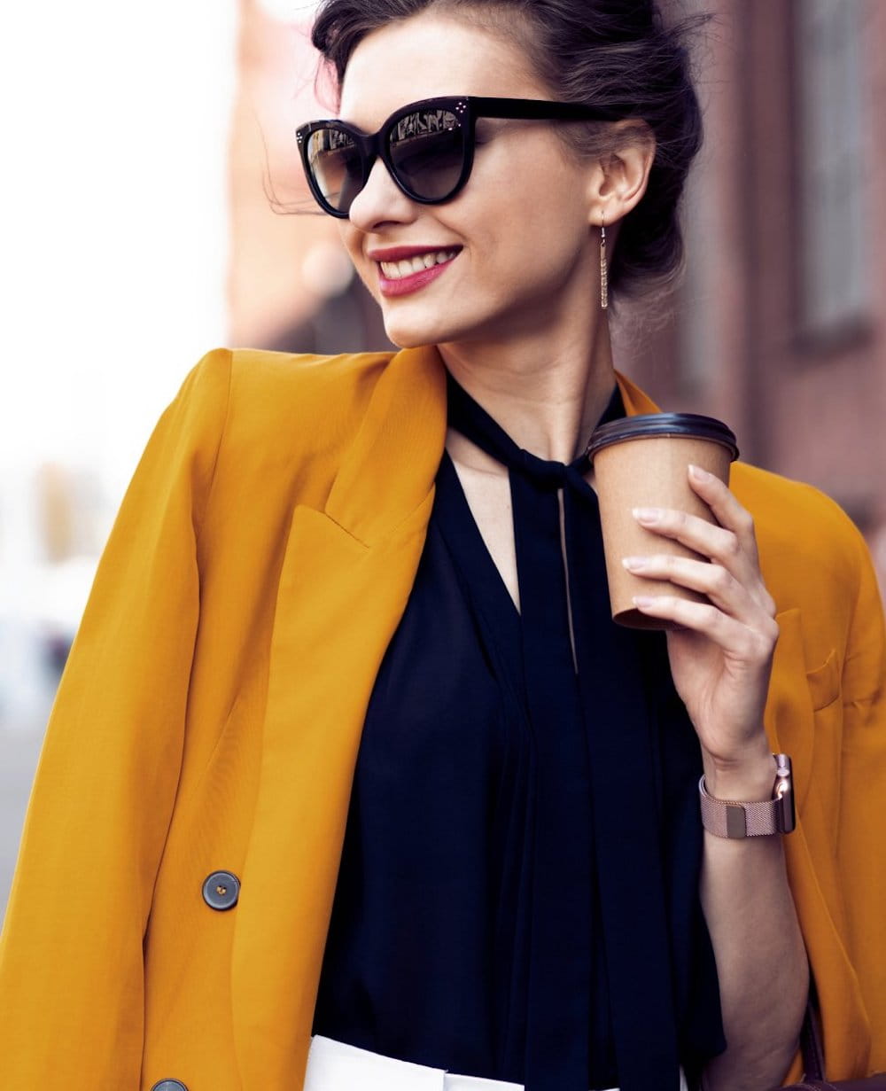 vi peel patient model walking down a street smiling with a coffee